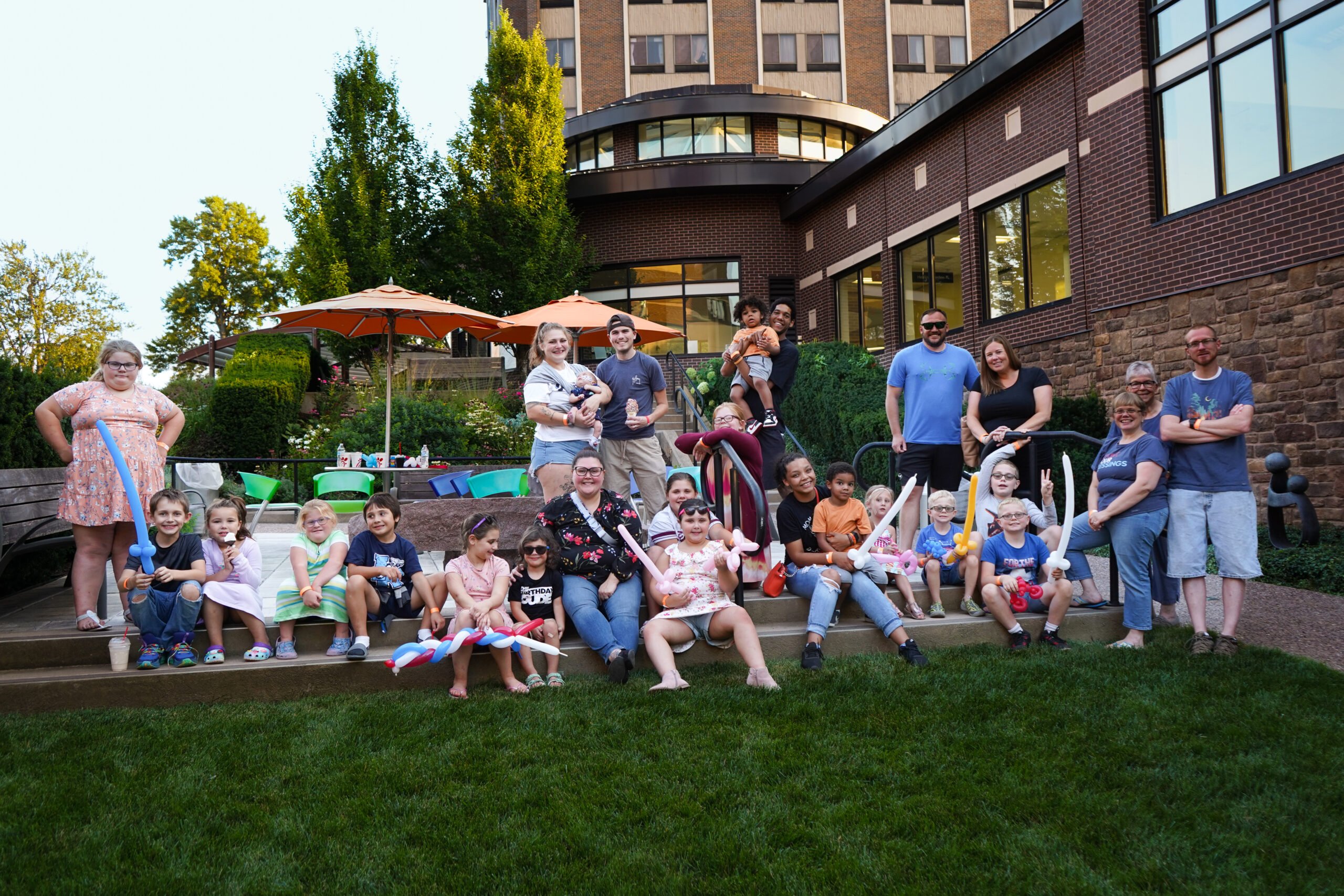 NNY Children's Miracle Network families. They are posing at the Healing Gardens at Samaritan Medical Center.