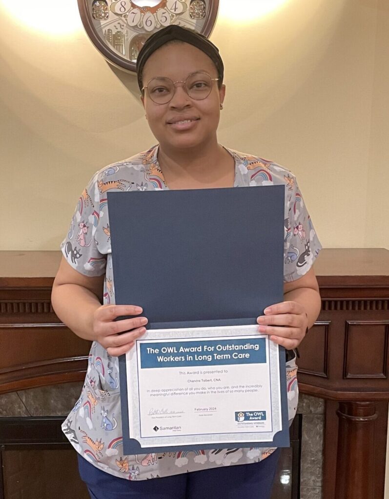 Chandra Tolbert's portrait holding her OWL Award certificate.