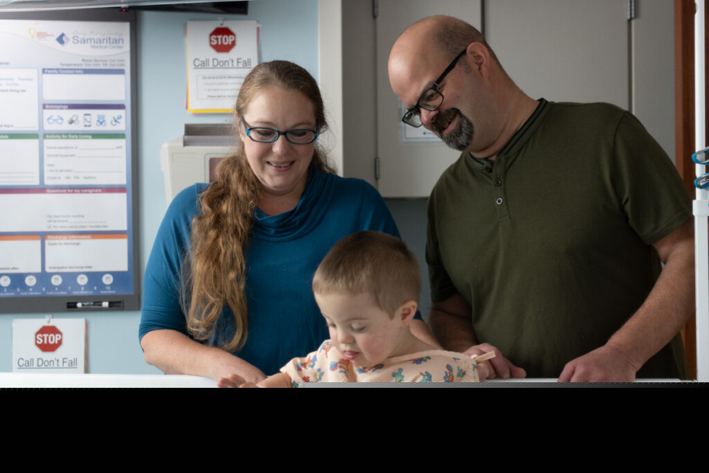 Illustrative photo shows a family with their infant son. The child plays in the bed.